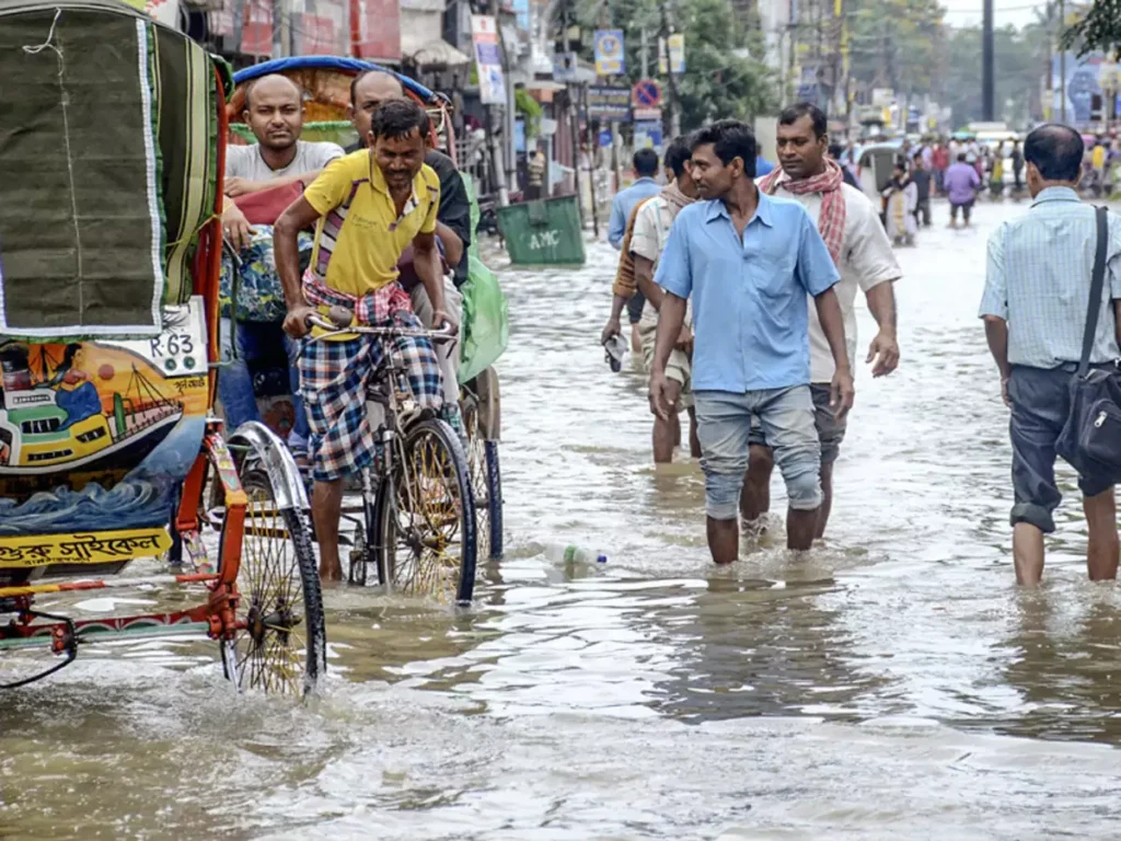 Commuters cross a waterlogged street in Agartala (PTI Photo)